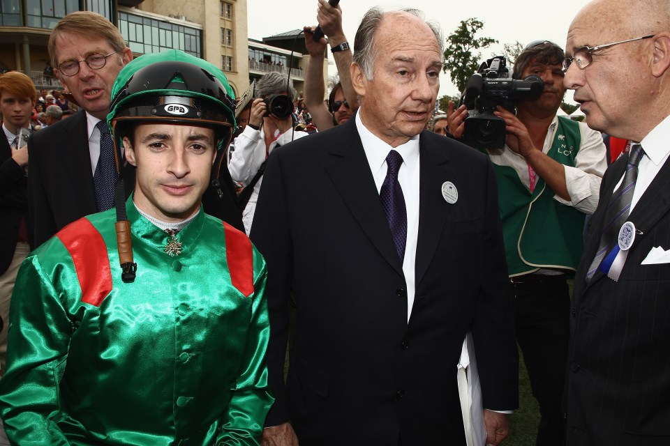 Prince Karim Aga Khan IV with a jockey at a horse race.