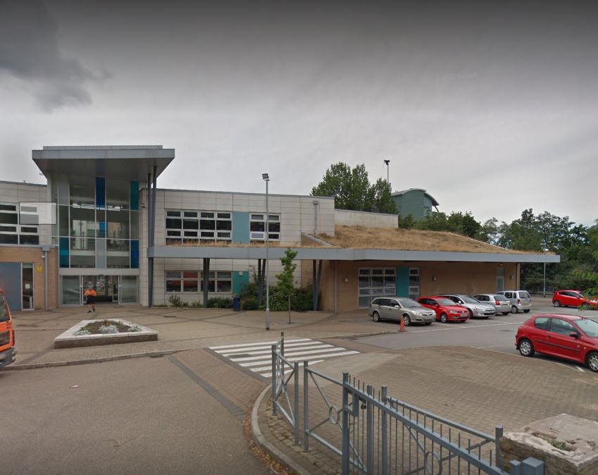 School building with cars parked in front.