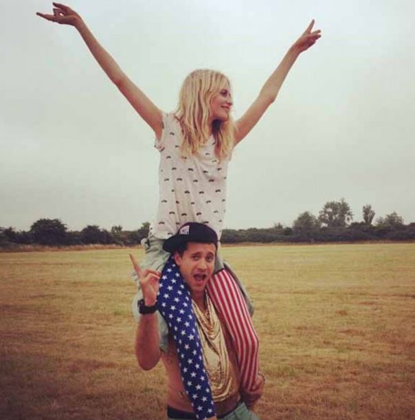 Woman giving a man a piggyback ride in a field.