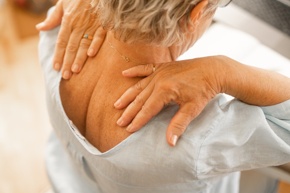 Senior woman massaging her shoulders.