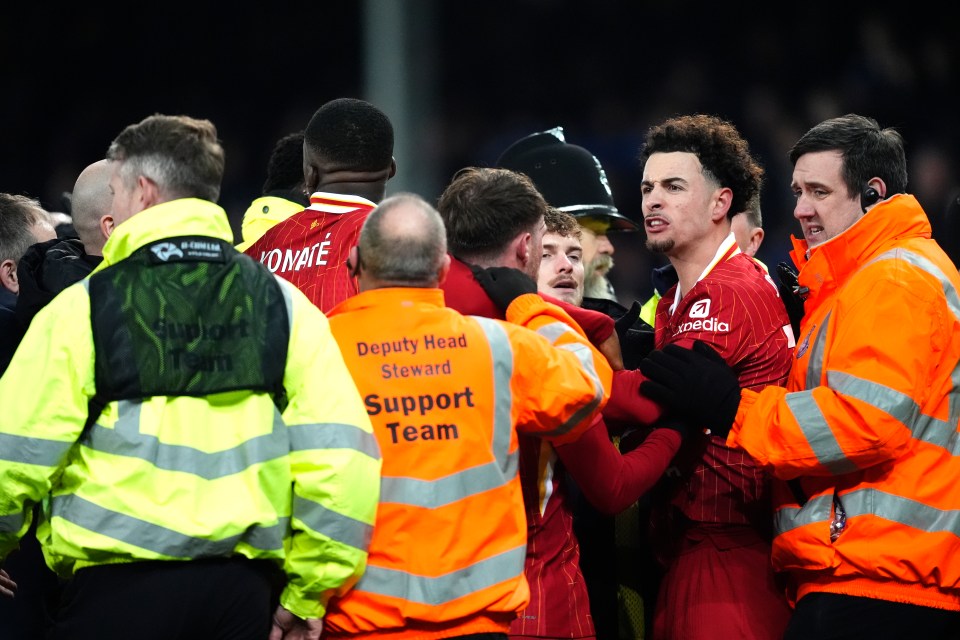 Ground staff separating two soccer players after a post-game altercation.