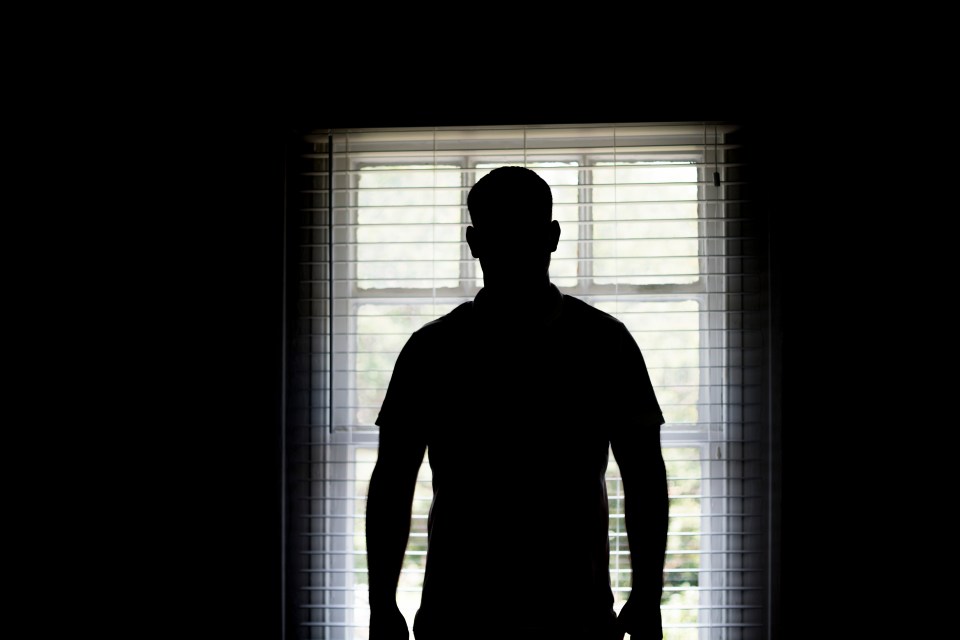 Silhouette of a man standing at a window.