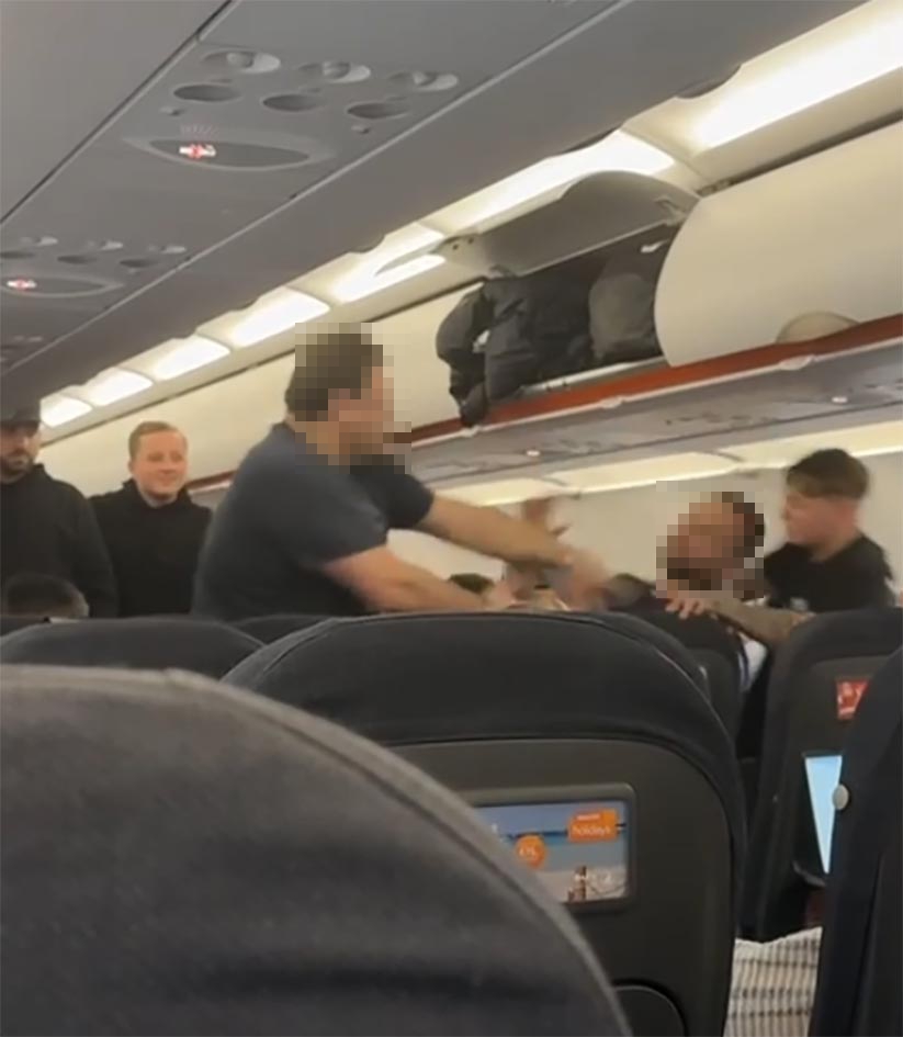 A man slapping another man on a plane.