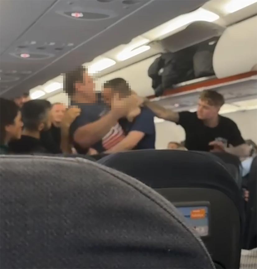 A man slapping another man on a plane.