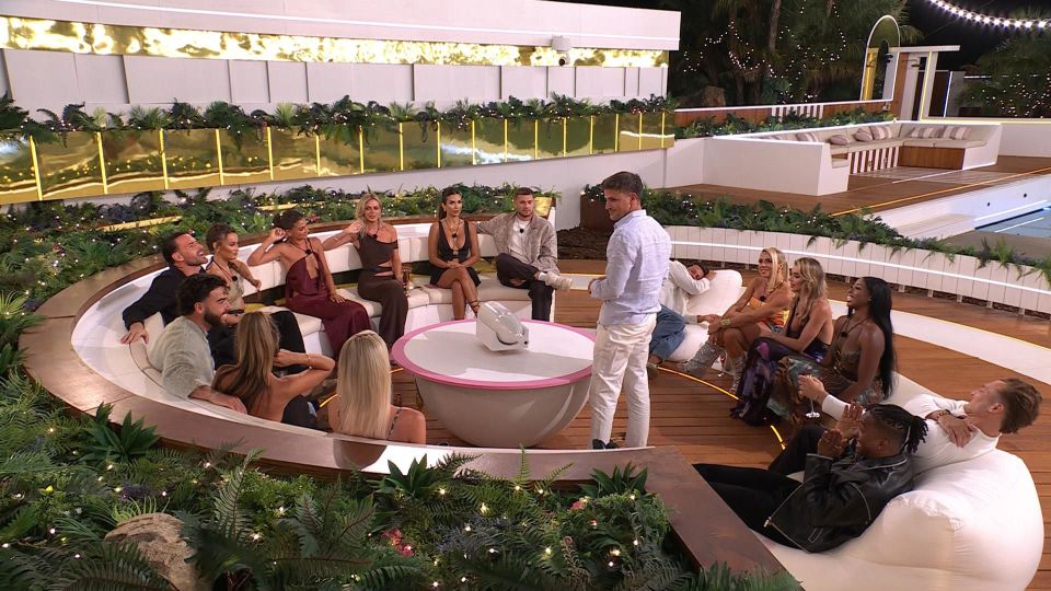 Love Island All Stars cast members gathered around a table.