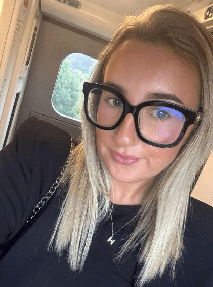 Woman wearing glasses on a train.