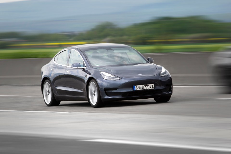 Tesla Model 3 driving on a highway.