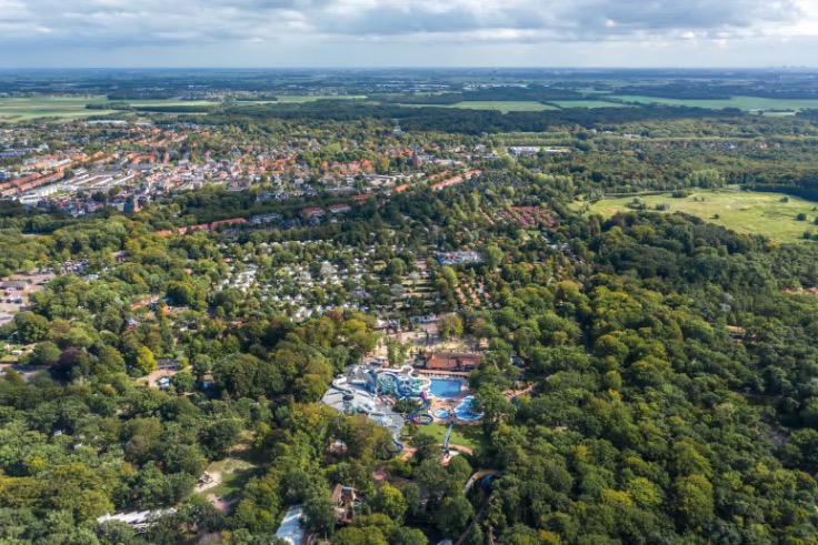 Aerial view of Duinrell resort in the Netherlands, showing a water park and campsite surrounded by trees.