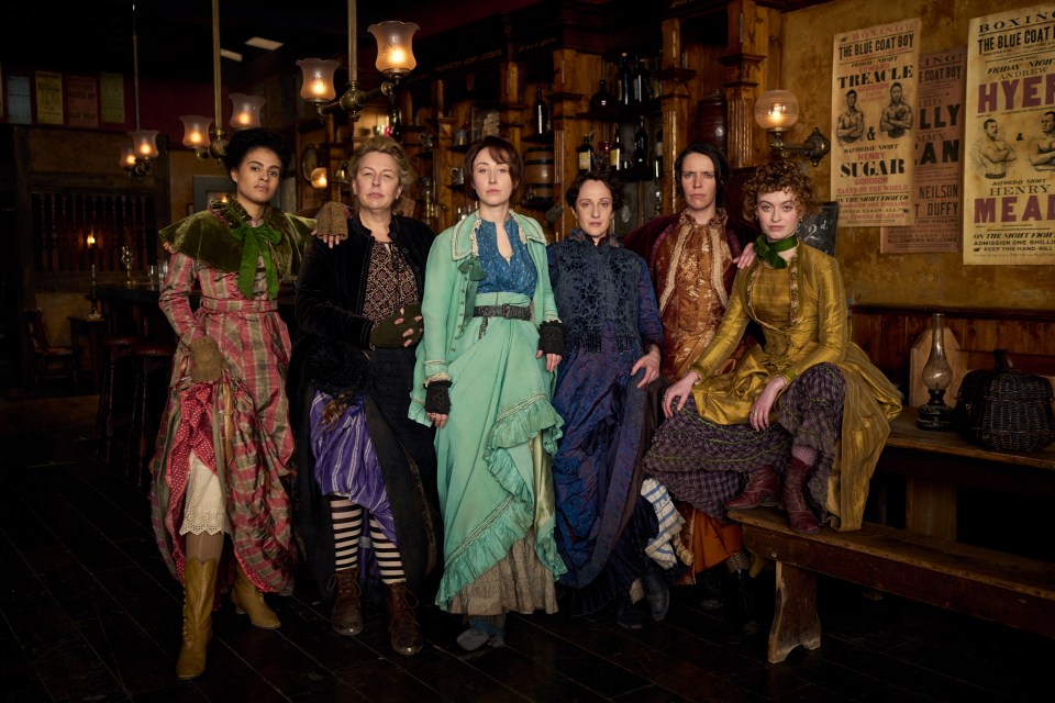 Cast photo of six women in period costume.