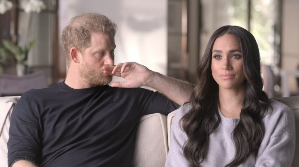 Prince Harry and Meghan Markle sitting on a couch, discussing a miscarriage.