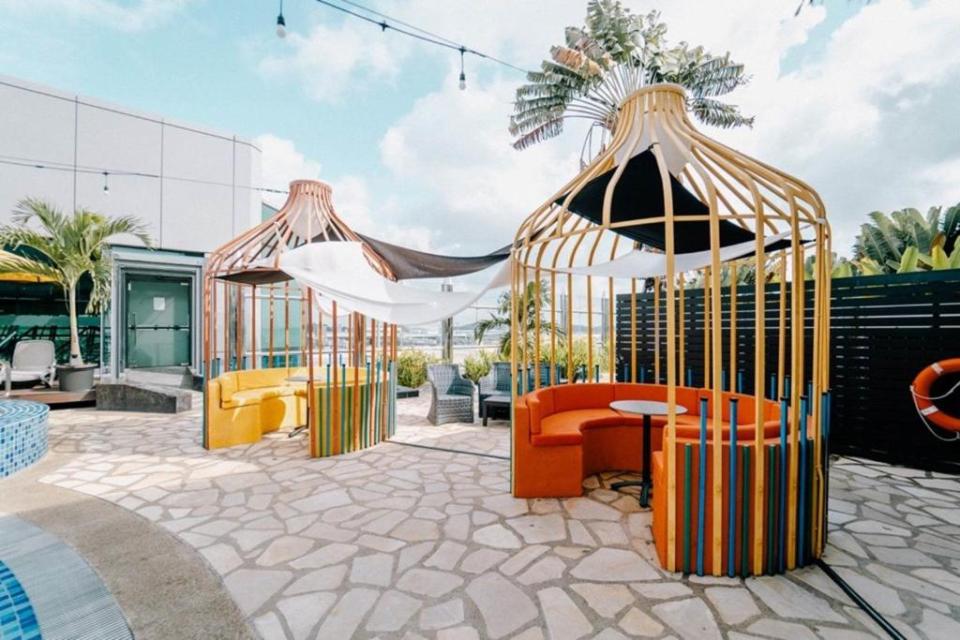 Outdoor seating area with colorful, birdcage-like structures.