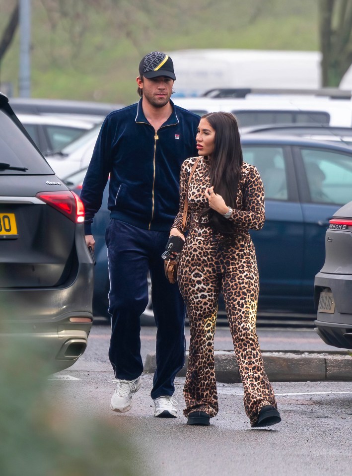 Jack Fincham and Chloe Brockett walking in a parking lot.