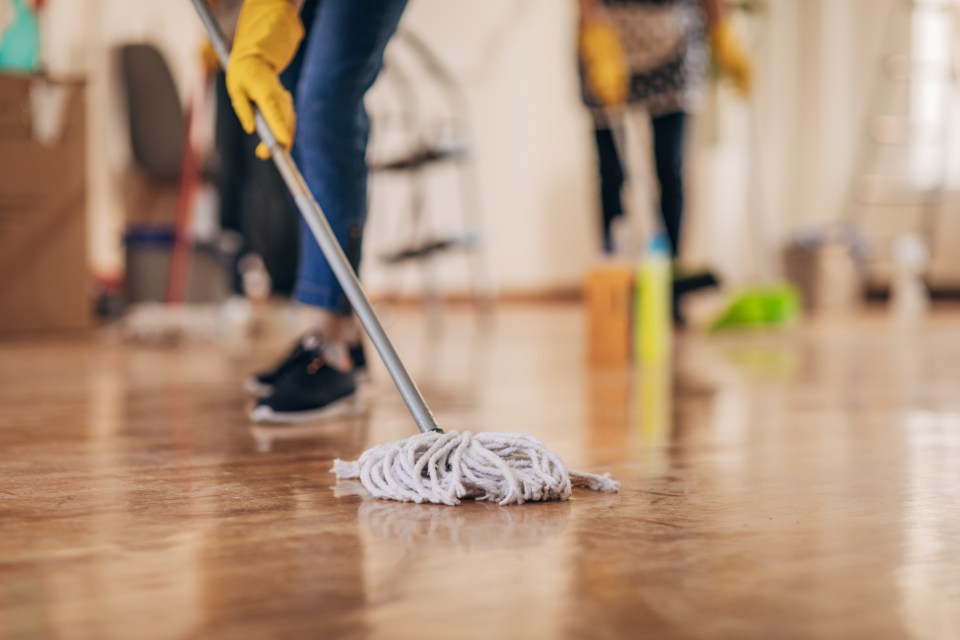 Two women mopping a floor.