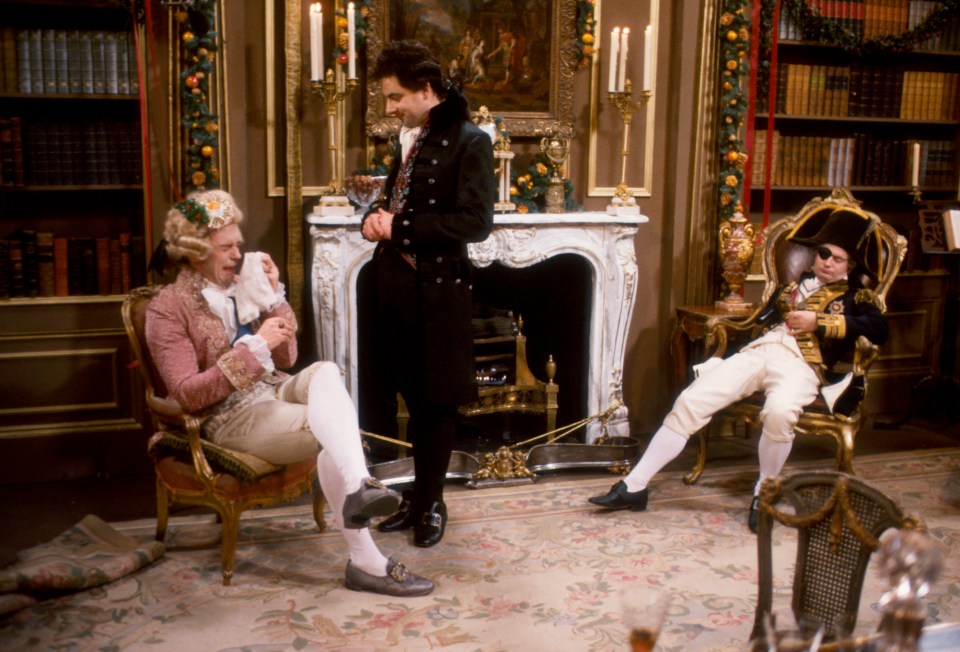 Scene from Blackadder the Third, featuring Prince George, Edmund Blackadder, and Lord Nelson in 18th-century attire.