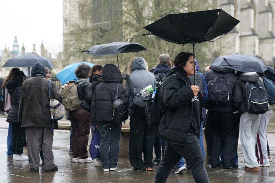 People sheltering from the rain under umbrellas.