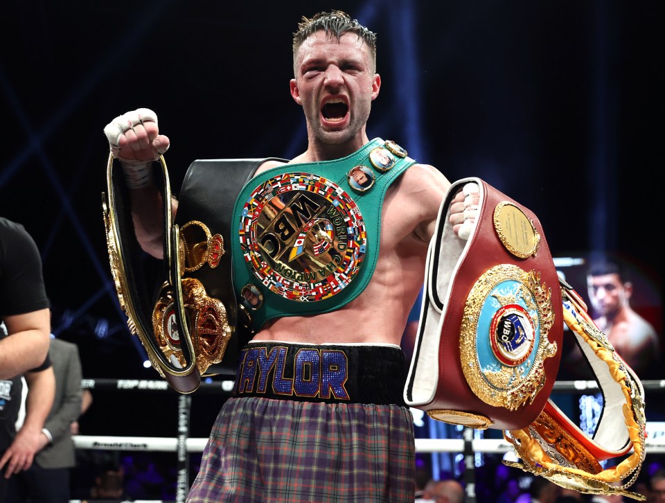 Josh Taylor, victorious super lightweight boxing champion, holding his championship belts.