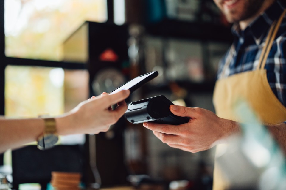 Person using a smartphone to make a contactless payment.