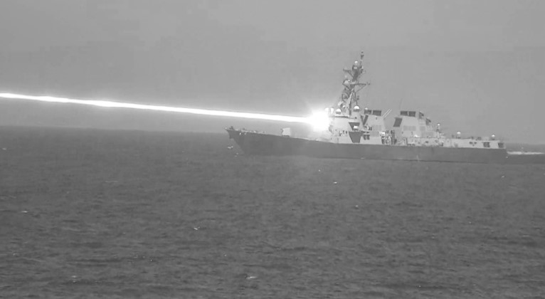 US Navy warship firing a laser weapon.