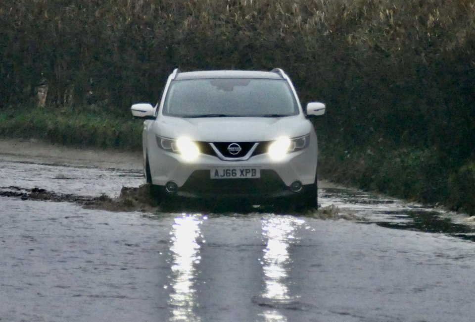 Car driving through floodwater.