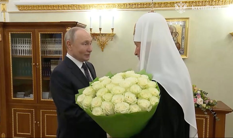 Vladimir Putin presenting a bouquet of white roses to Patriarch Kirill.