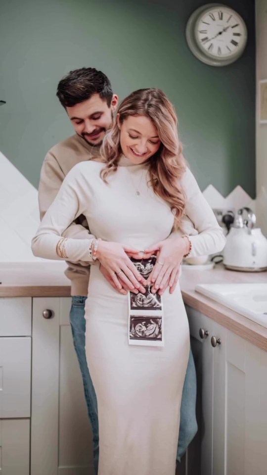 Pregnant couple holding ultrasound images.