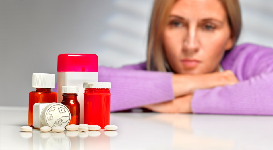 Woman contemplating pills.