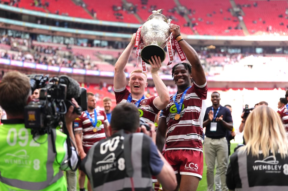 Wigan Warriors players celebrate with the trophy after winning the Betfred Challenge Cup final.