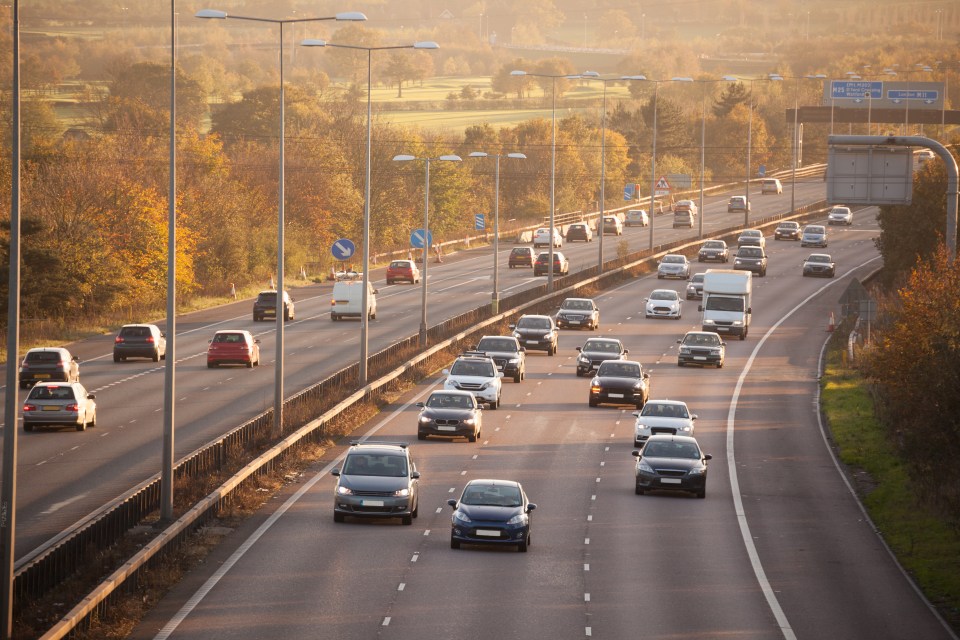 Traffic on a multi-lane highway at sunset.