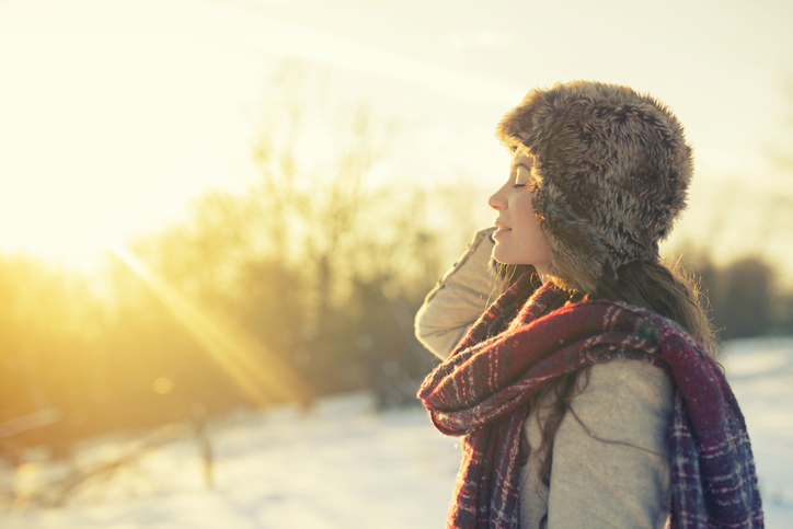 Woman enjoying a sunny winter day in the mountains.