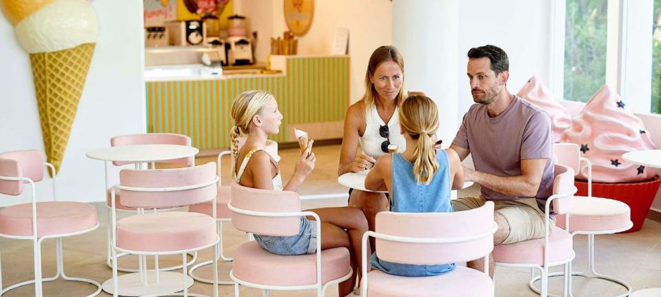 Family enjoying ice cream at an ice cream parlor.