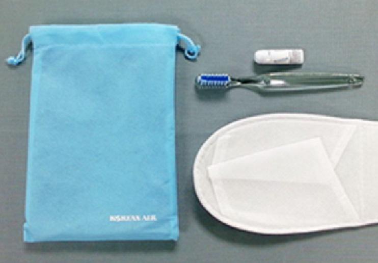 Korean Air amenity kit: slippers, toothbrush, toothpaste, and a bag.