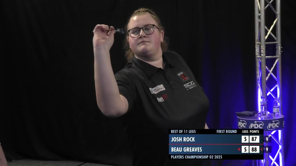 Beau Greaves throwing darts in a darts match.