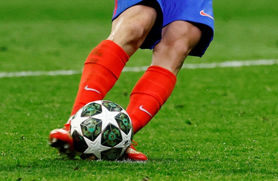 Soccer player kicking a Champions League ball.