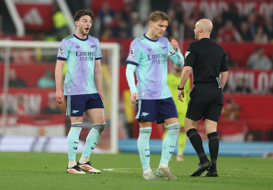 Declan Rice of Arsenal speaks with a referee on the soccer field.