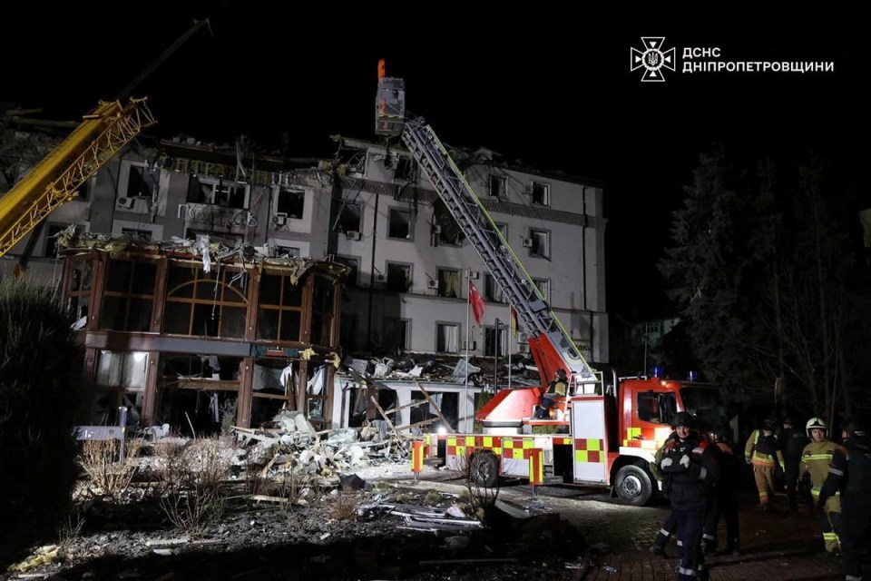 Rescue workers at a damaged hotel after a missile strike.