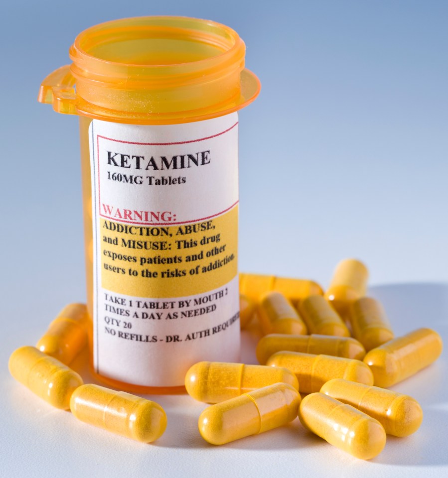 Prescription bottle of ketamine with spilled pills; warning label highlights addiction risks.