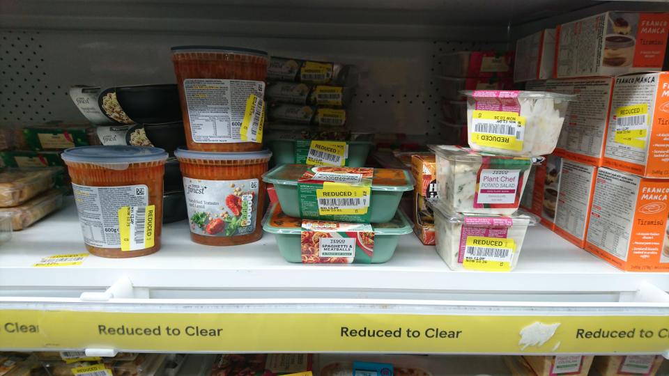 Reduced-to-clear food items on a supermarket shelf.