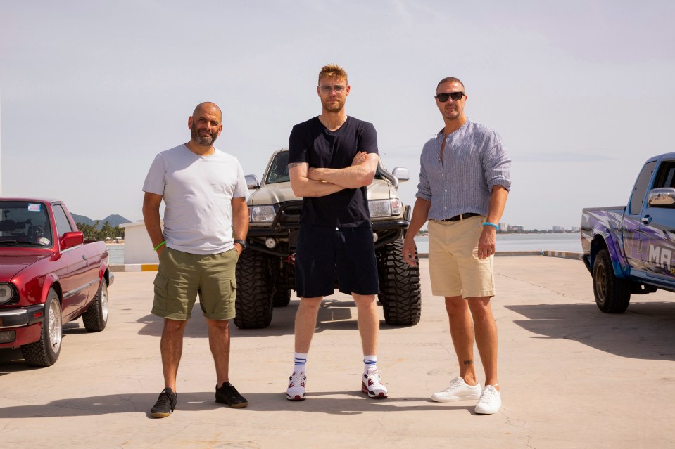 Three men standing in front of a modified truck.