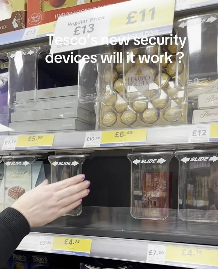 Tesco's new security devices on a shelf with chocolate.