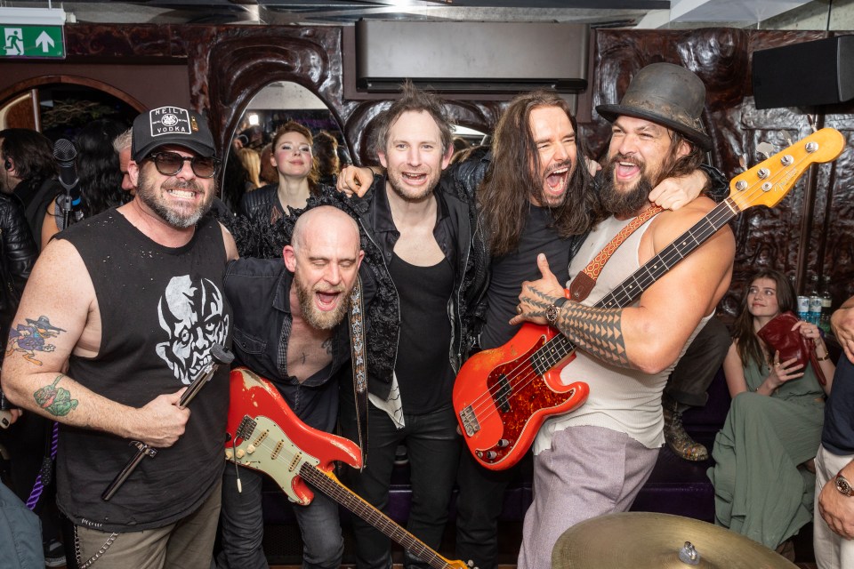 Jason Momoa and a band playing instruments.