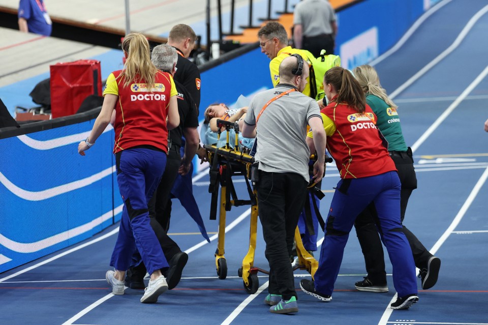 A runner being carried off on a stretcher after falling during a race.