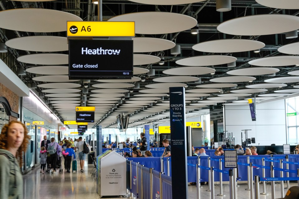 Heathrow Airport gate closed sign and passengers waiting to board.