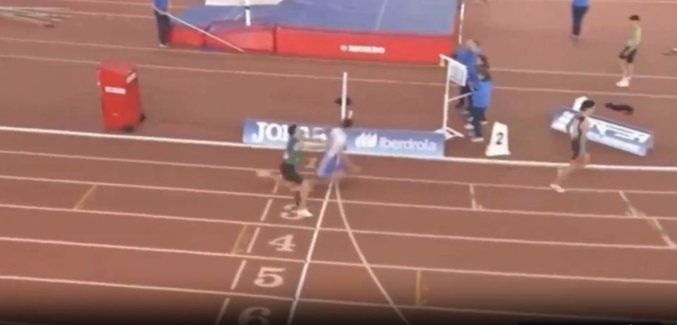 Two runners sprinting towards the finish line on a track.