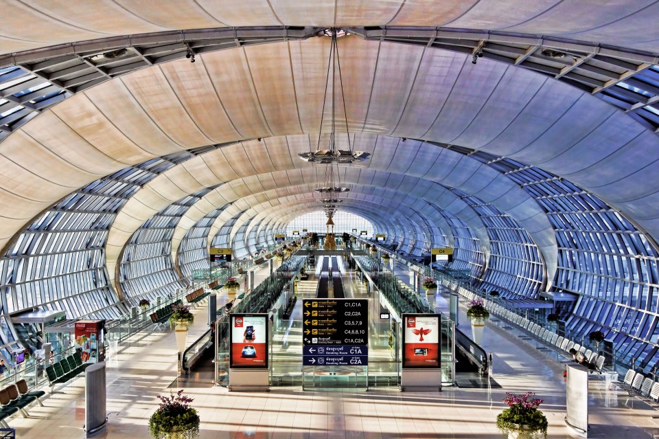 Airport terminal interior with moving walkways and seating.