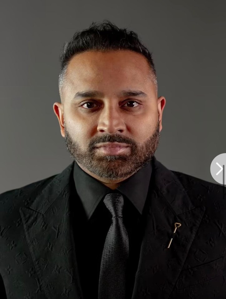 Headshot of a man in a black suit.