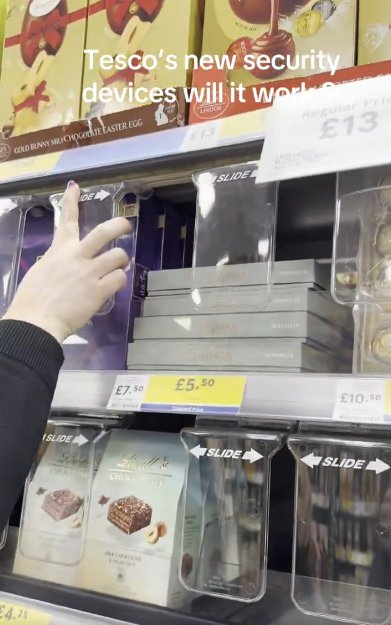 Tesco's new security devices on a shelf with chocolate.