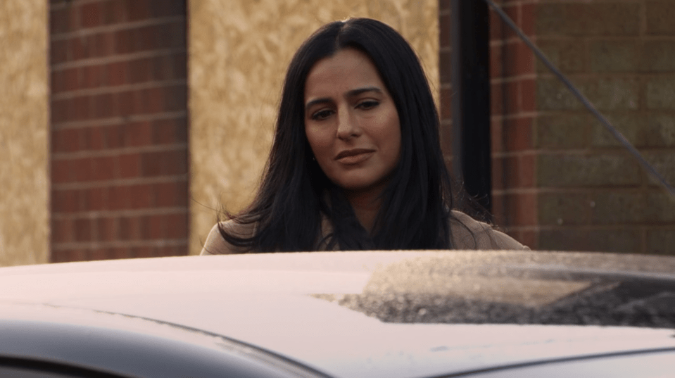 Woman looking down at a car.