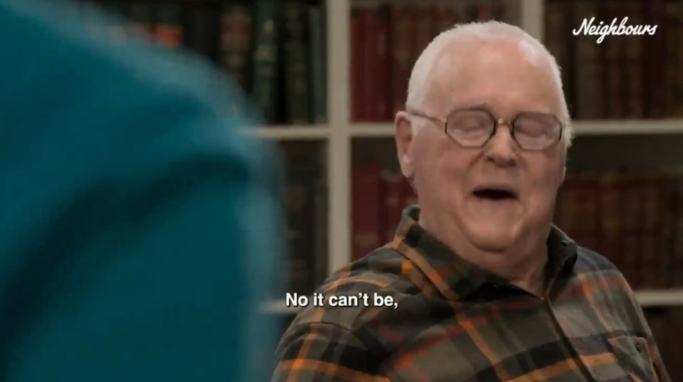 Screenshot of a man saying, "No it can't be," in front of bookshelves.