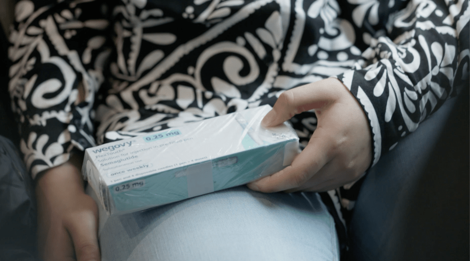 A person holding a box of Wegovy 0.25 mg semaglutide injection pens.