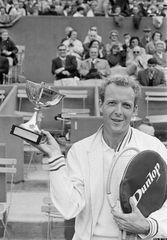 Fred Stolle holding a trophy and tennis racket.